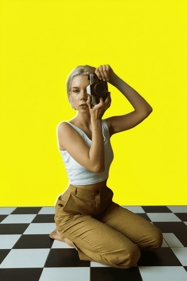 Ropa Femenina con Estilo - Ella-Todo para Ella-Colecciones para Ella, mujer rubia tomando fotos con cámara, rodeada de plantas.