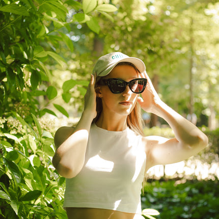 Mujer con gafas de sol Hanukeii® Isla Tortuga Black / Black en un entorno natural al aire libre.